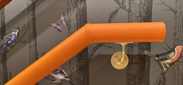 orange leather handrail with brass brackets